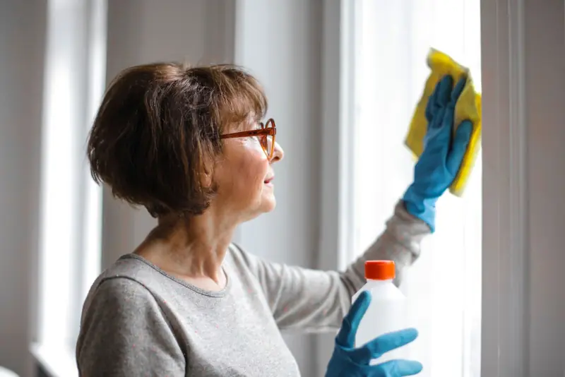 An Olivers cleaner polishing glass on commercial premises